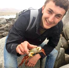 A Picture of Jamie picking up a crab